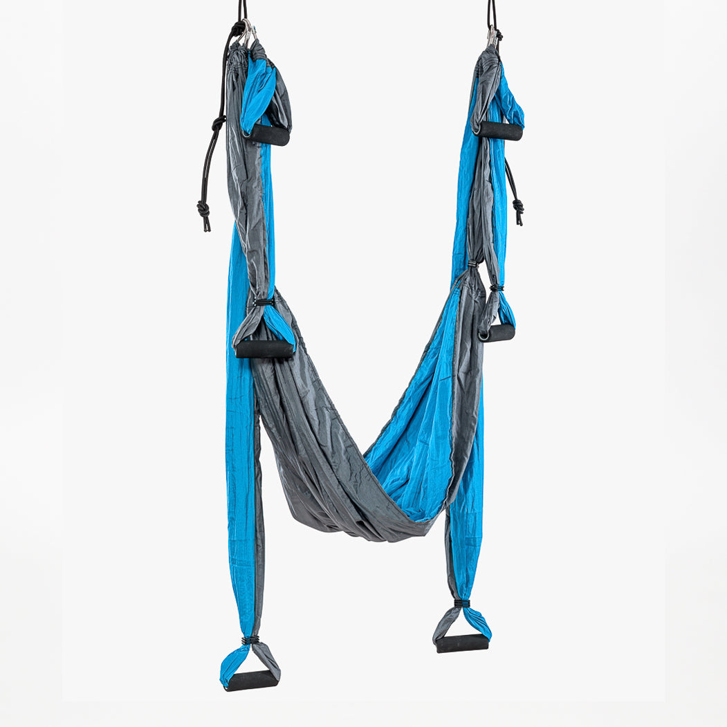 A turquoise Aerial Yoga Swing shown hanging from the ceiling | TRIBE Yoga